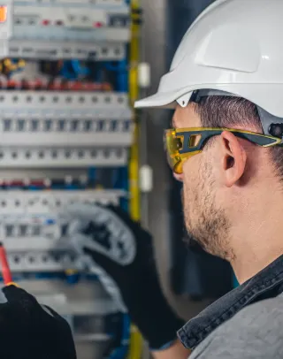 Persona revisa un tablero eléctrico